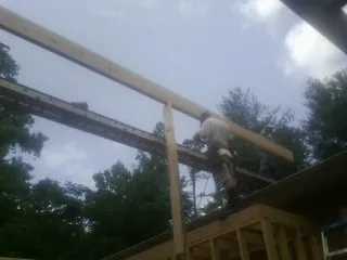 Carpenter setting a ridge beam over a new addition frame — Ice Dam Removal by Roofing Brothers in Ocean Park